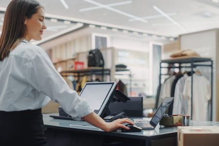 Clothing Store: Businesswoman and Visual Merchandising Specialist Uses Laptop To Create Stylish Collection. Fashion Shop Sales Retail Manager Checks Stock. Small Business Owner and Designer Works