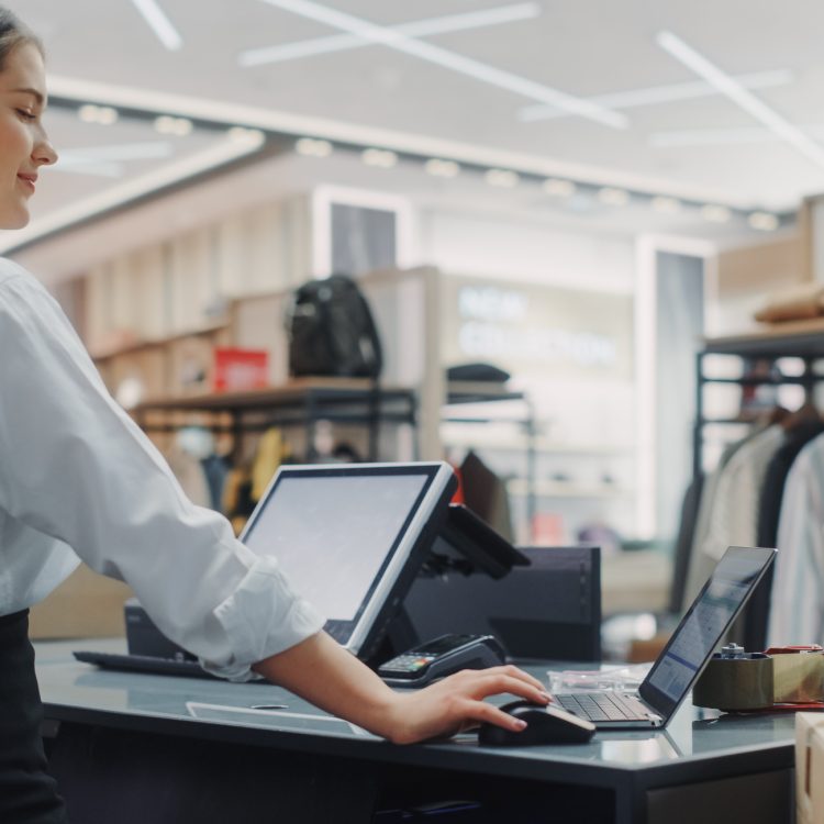 Clothing Store: Businesswoman and Visual Merchandising Specialist Uses Laptop To Create Stylish Collection. Fashion Shop Sales Retail Manager Checks Stock. Small Business Owner and Designer Works