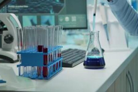 close-up-of-scientis-testing-liquid-sample-late-at-night-using-micropipette-for-medical-treatment-in-laboratory-team-examining-virus-evolution-using-high-tech-for-vaccine-development